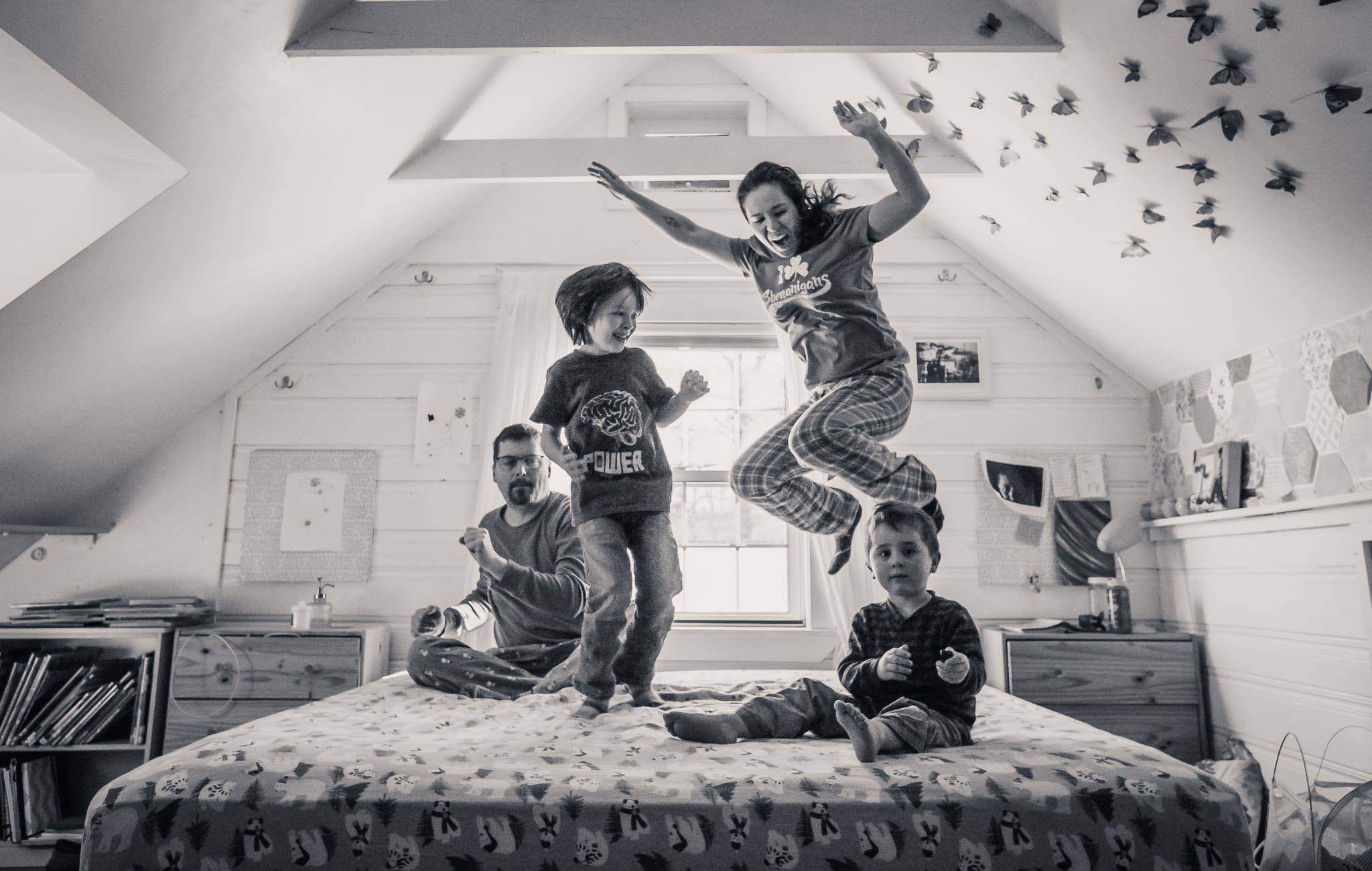 family jumping on bed