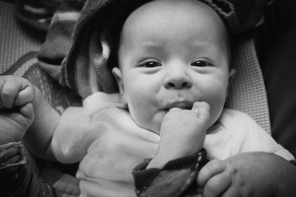Infant chewing toes and smiling