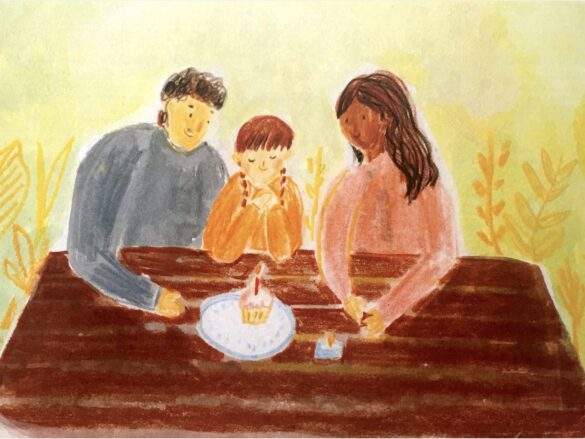 Screenshot-2023-06-09-at-12.26.48-PM Girl and parents with birthday cupcake on picnic bench