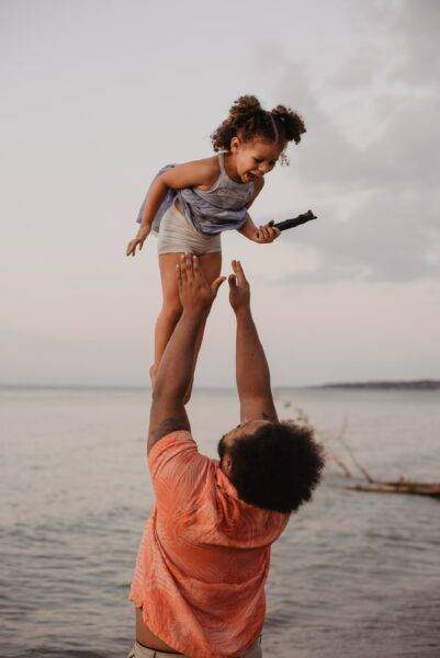 father and daughter playing on beach