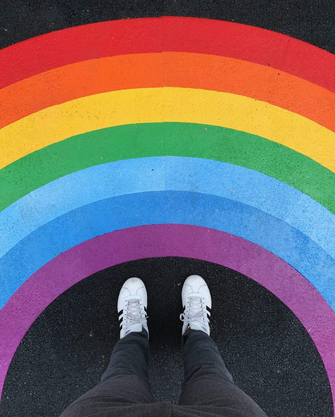 feet surrounded by rainbow mural