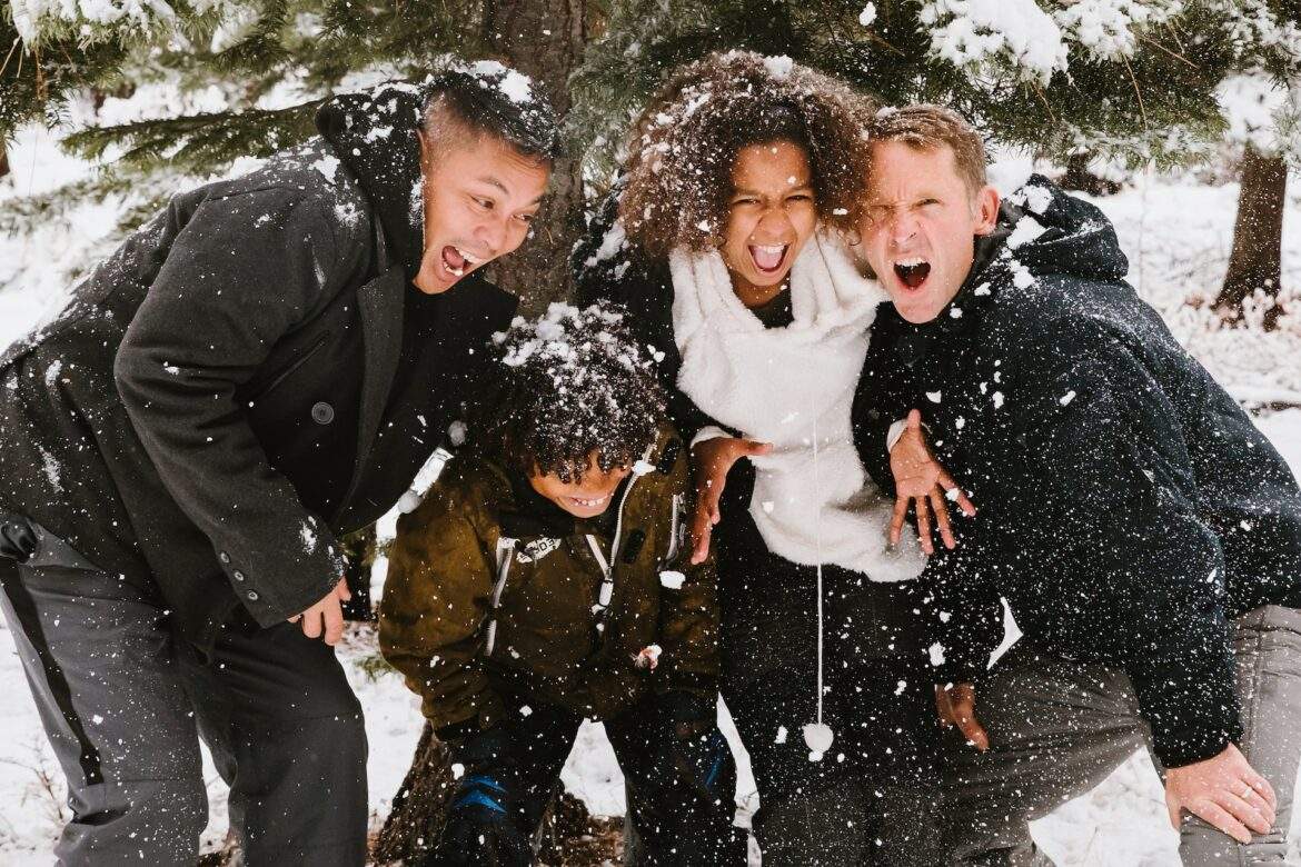 two-dad family of four playing in the snow