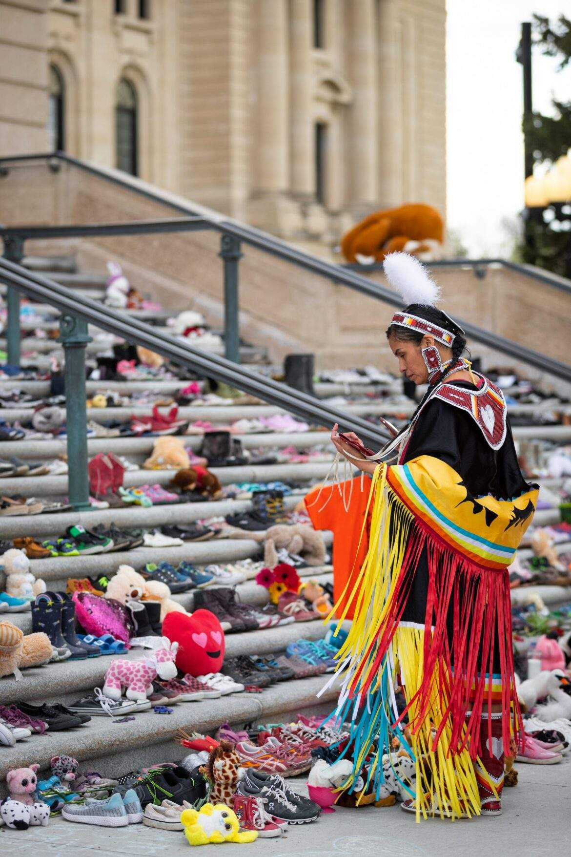 toys and shoes left on steps in honor of residential school victims
