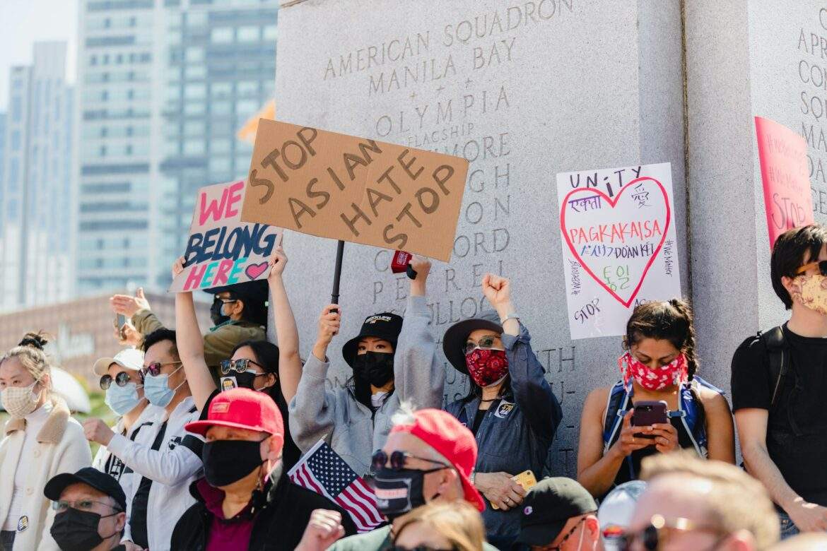 photo of Stop Asian Hate rally. protestors standing in front of american squadron manila bay memorial holding we belong here signs. by jason leung