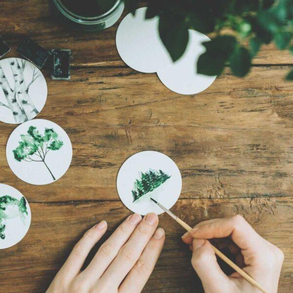 hands painting tiny trees