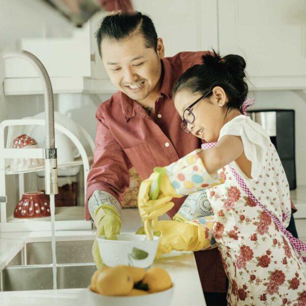 father and daughter wash dishes together