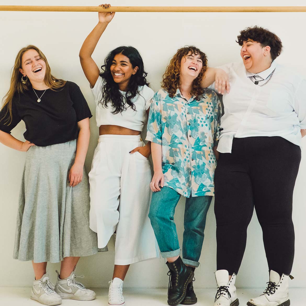 four people standing and laughing