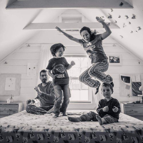 family jumping on bed